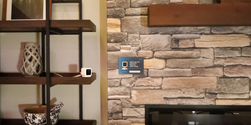 An Alexa home camera is set up on a book shelf.