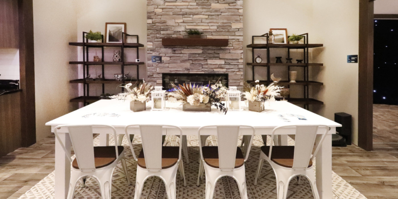 A Dinning room with a white table and chairs, fireplace, and two bookshelves.