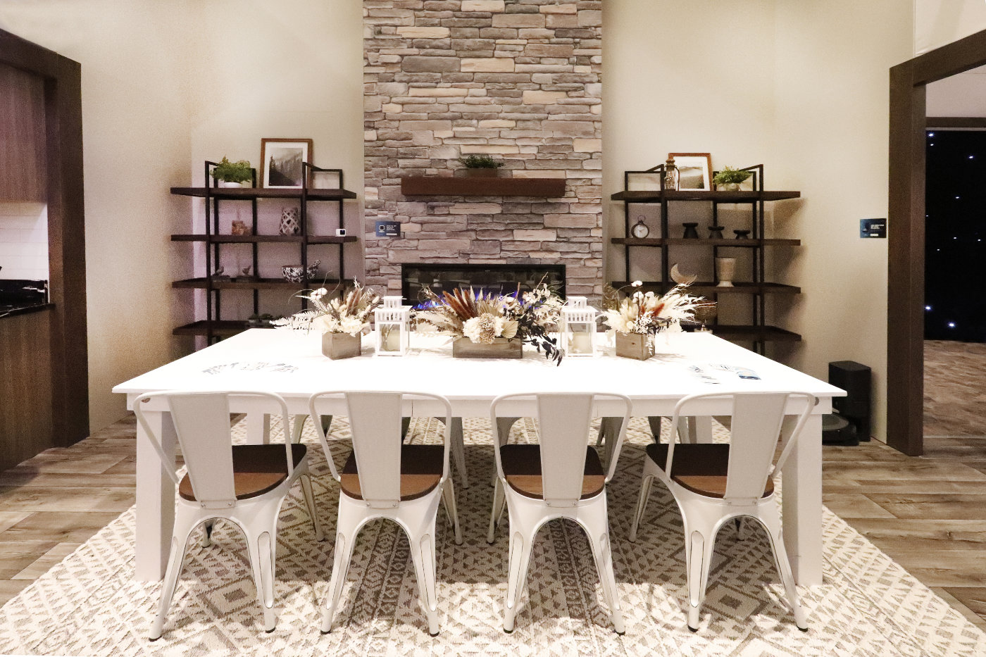 A Dinning room with a white table and chairs, fireplace, and two bookshelves.