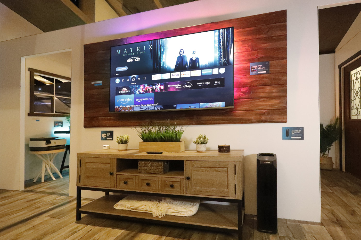 A TV and entertainment center with various Alexa tech on them